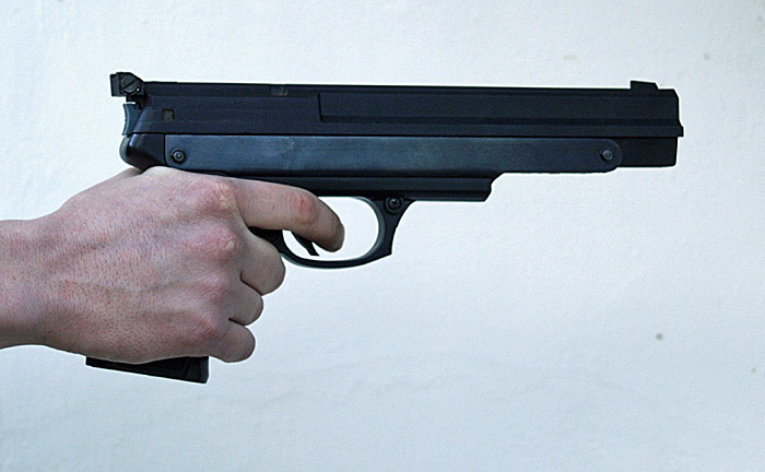 a hand holding a gun and pointing it at the camera