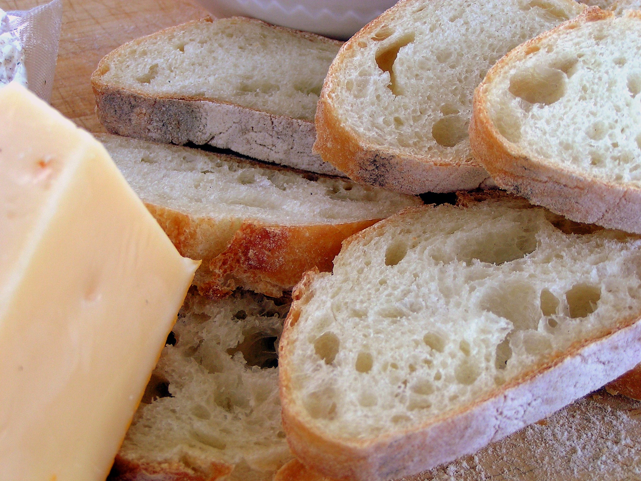 a loaf of bread next to two slices of cheese