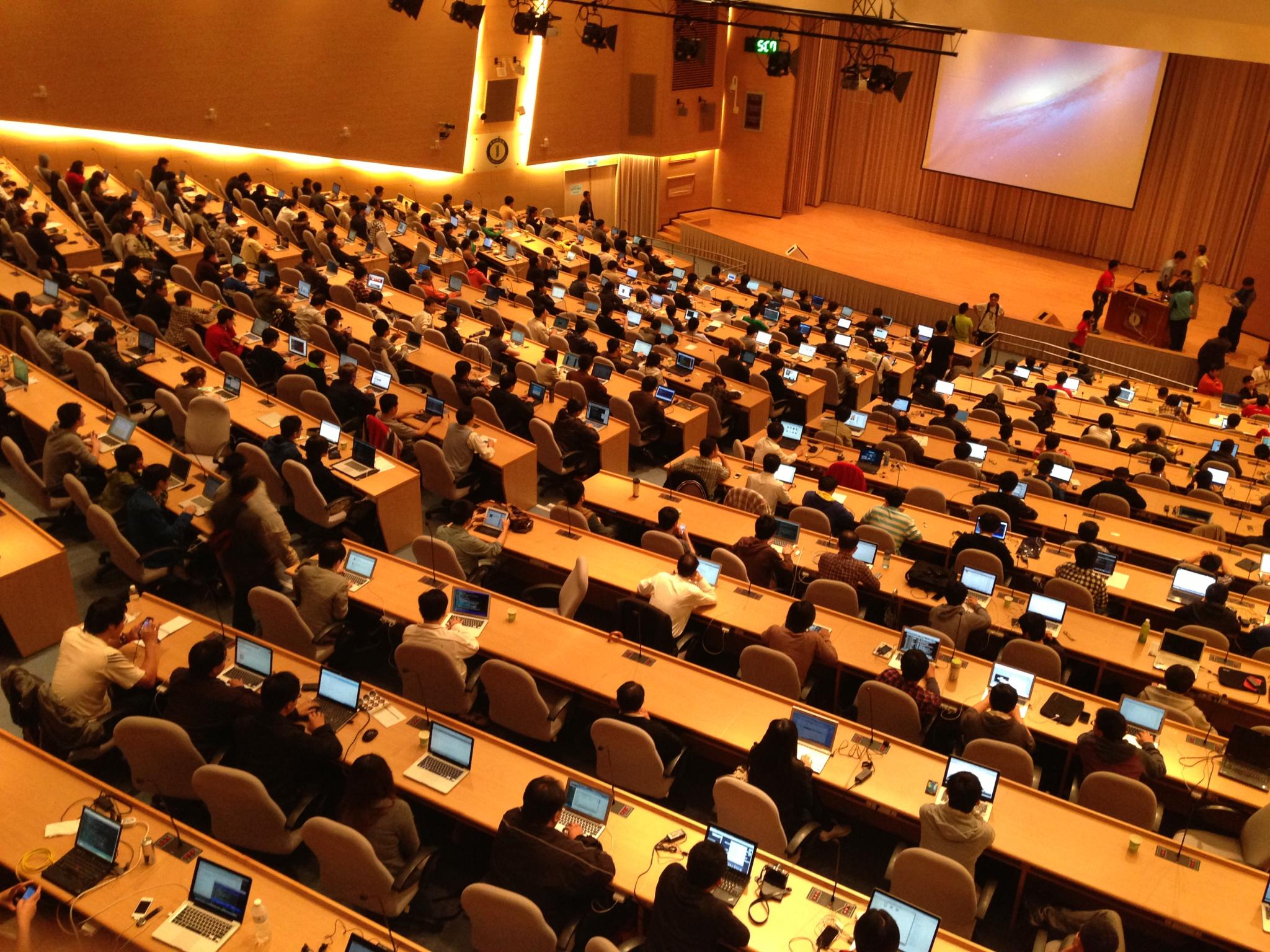 an auditorium full of computers and people using laptops