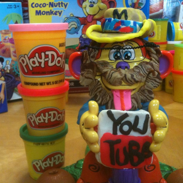 a stuffed toy holding a cup next to toys on a wooden table