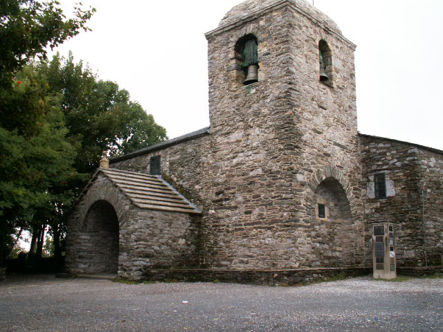 an old stone church stands in a gravel field