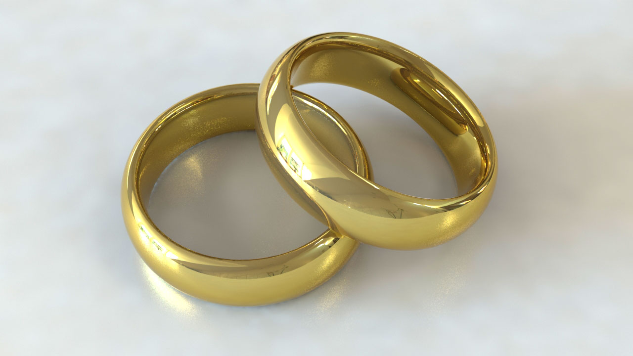 two wedding rings made of gold are laying on the surface