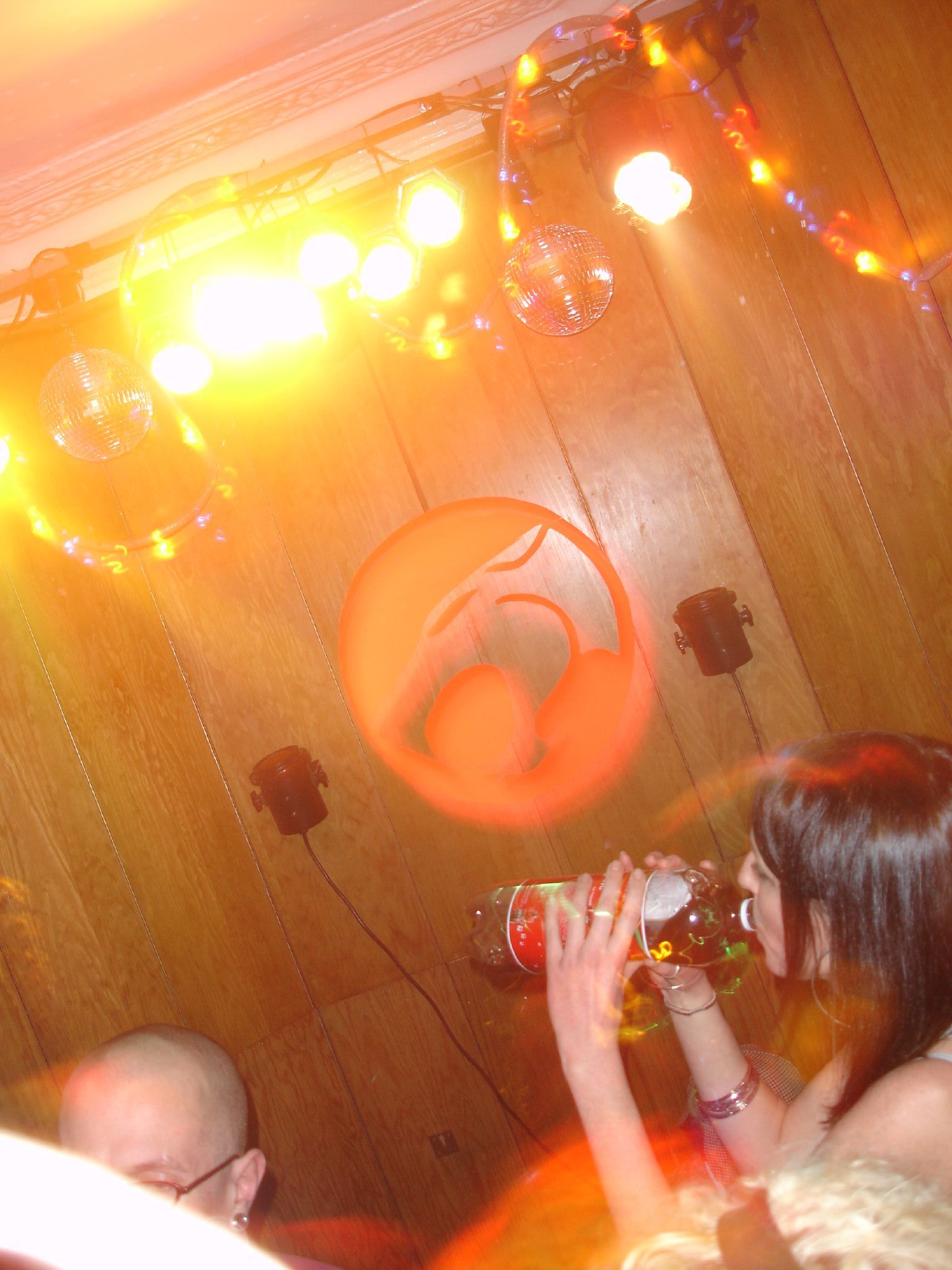 woman having a drink as she looks up at ceiling decorations