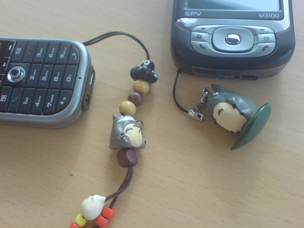 a wooden bead cord with two dolls, cell phone and keychain