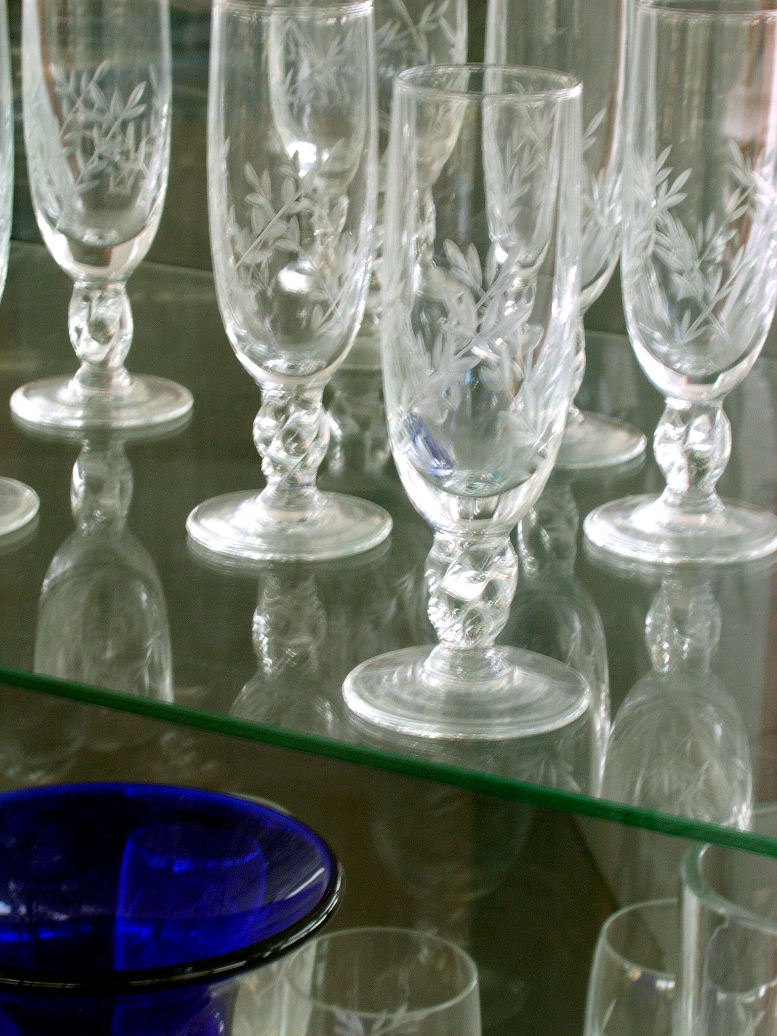 several empty glasses sit against a glass counter