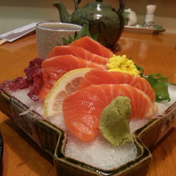 salmon sushi sits on ice and served with garnish