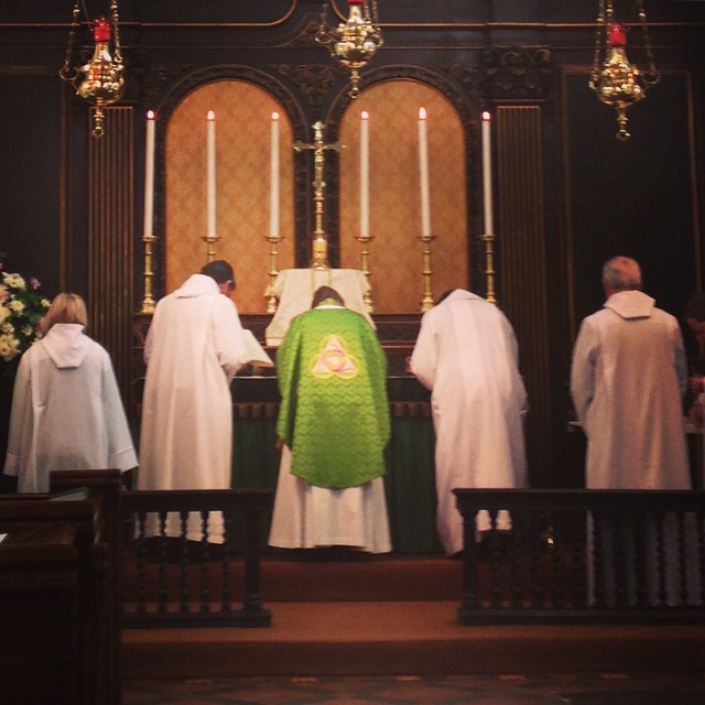 the people are wearing white robes and standing in front of the altar