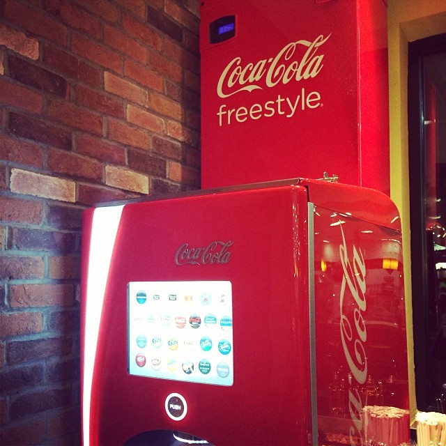 coke machine next to a coca cola machine with drinks coming out of it