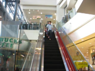 two escalators are descending to a small shop