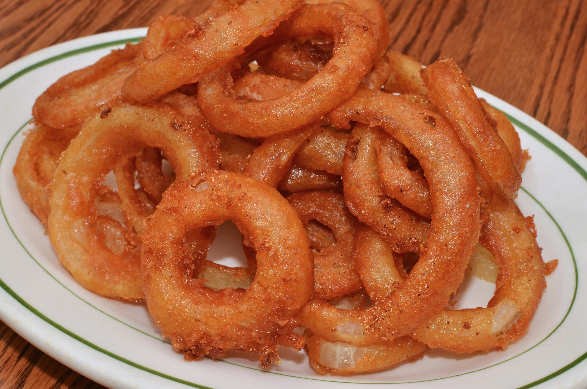 an onion rings on a plate sitting on a table