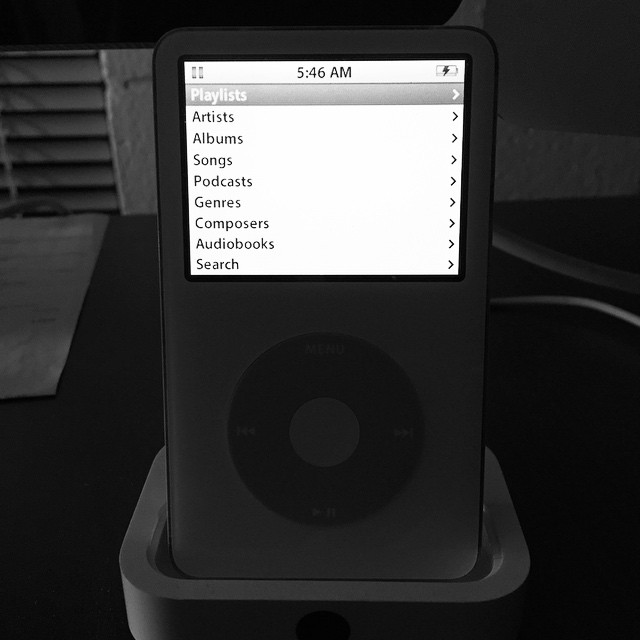 an ipod sits on a desk with its side in black and white