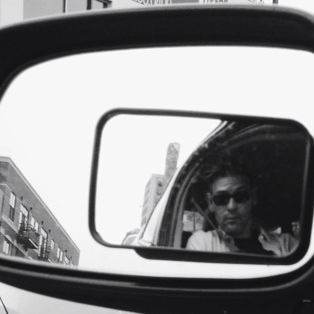 a man is shown in the reflection of a bus mirror