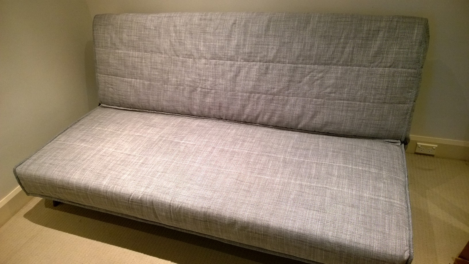 there is a futon couch in a small room