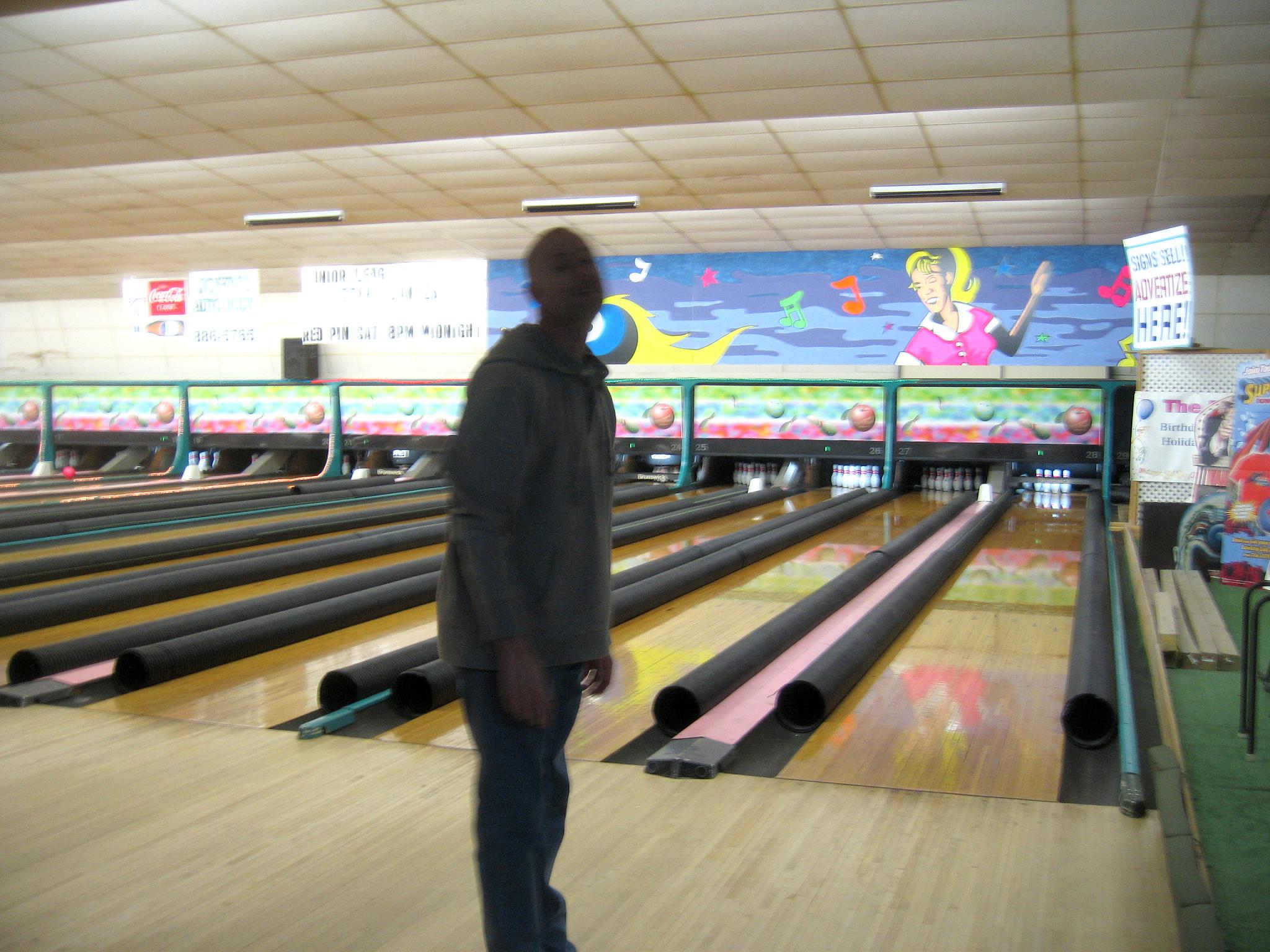 a man in the middle of bowling pins