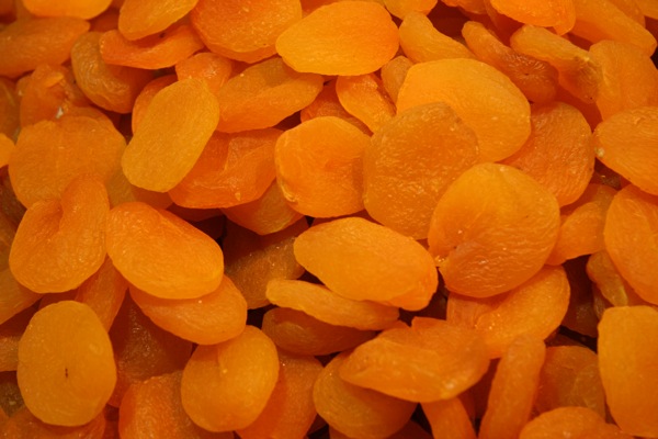 a pile of peeled orange food, with small pieces cut out