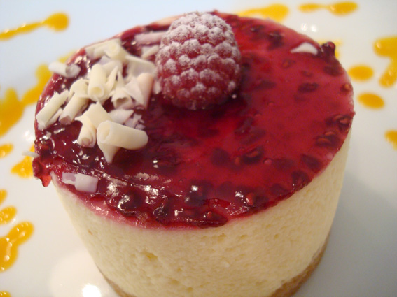 a cheesecake is covered in a red raspberry sauce