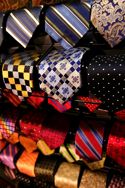 many ties are arranged on a rack for sale
