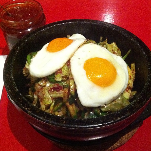 a black bowl filled with food and an egg