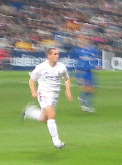 a soccer player running on a field with a ball