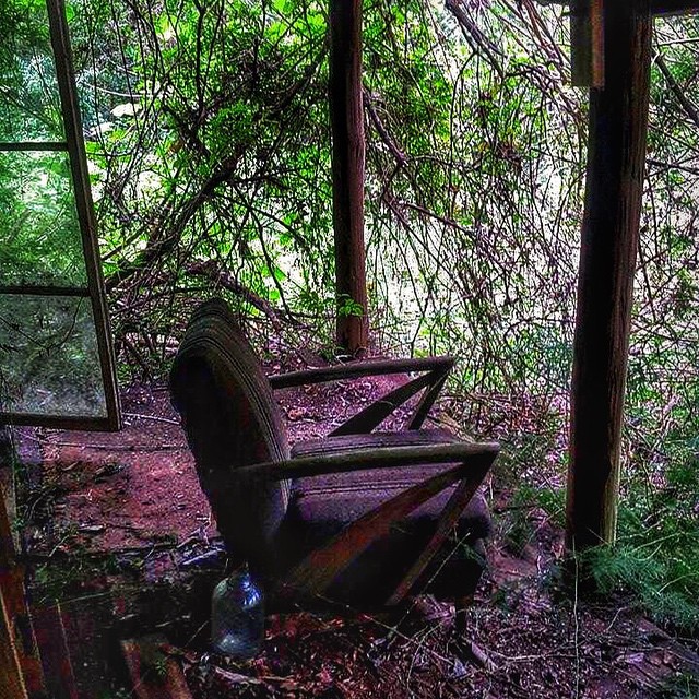 a very old abandoned chair in a very small room