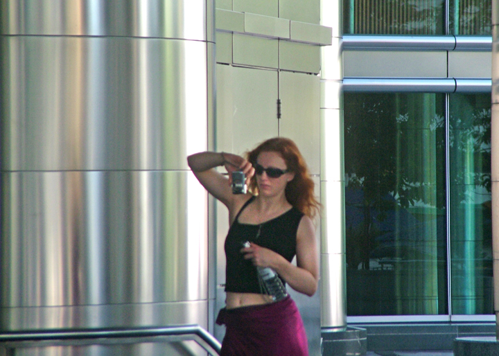 woman talking on cell phone by metal column