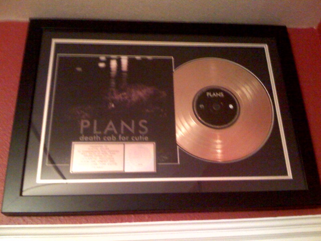 a gold colored record with the words plans written on it