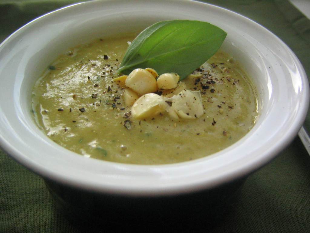 soup with beans, basil, and parsley in a white bowl