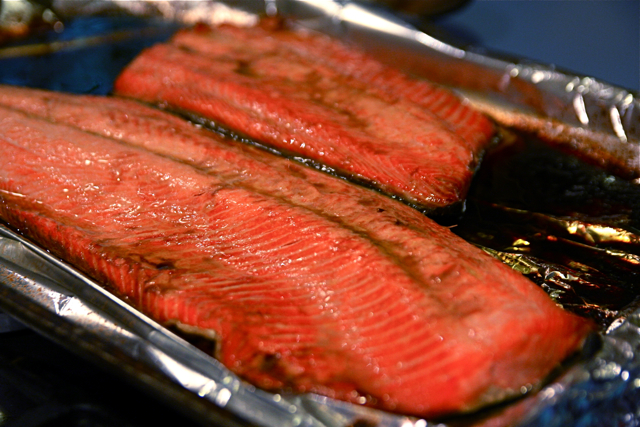 several fish fillets are being cooked on a grill