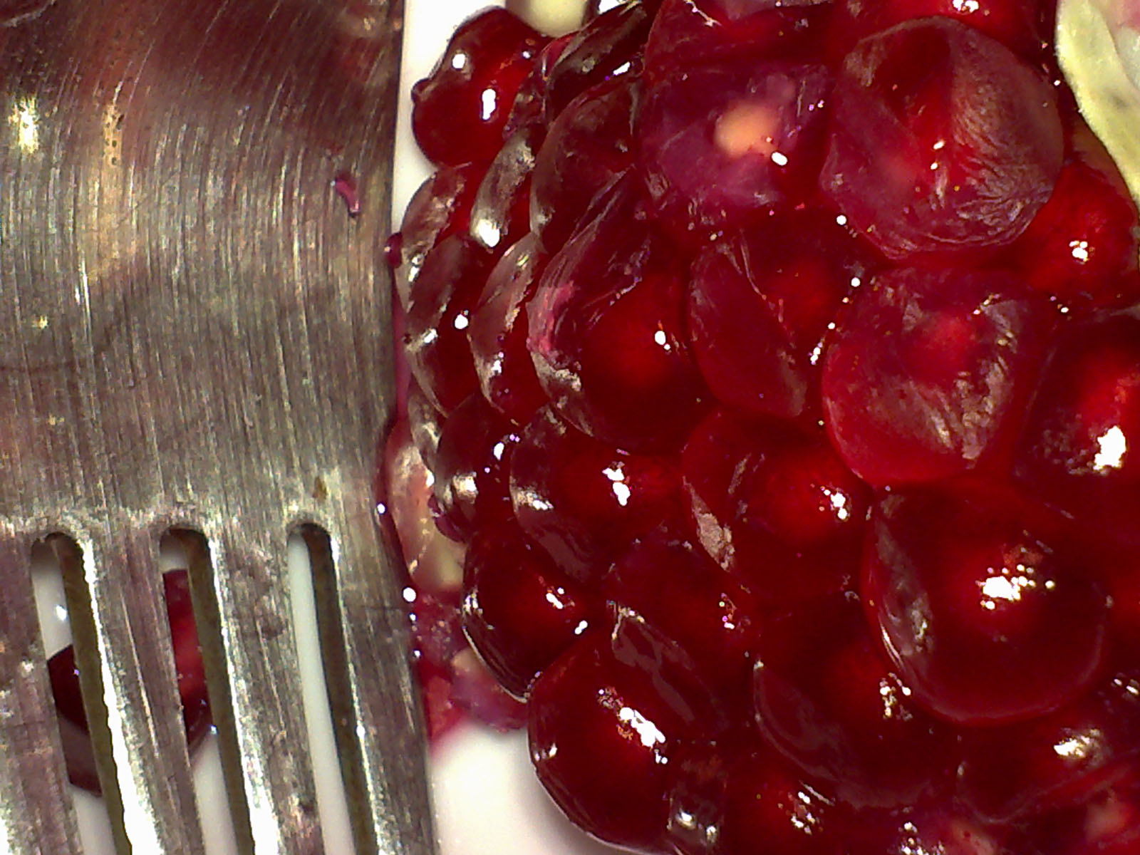 the cherries on the plate are next to a fork