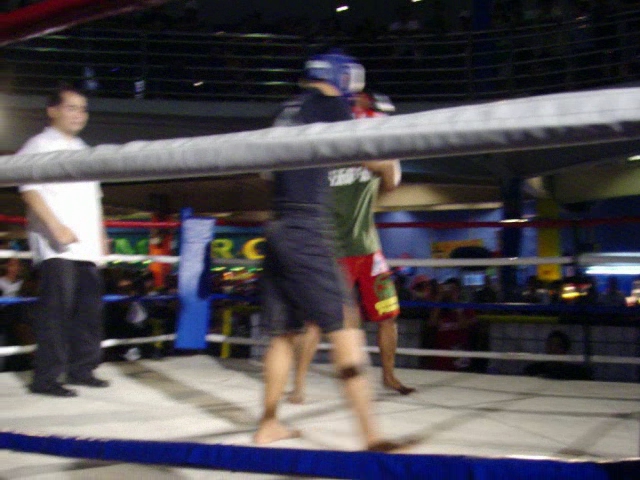 two young men are fighting inside an indoor arena