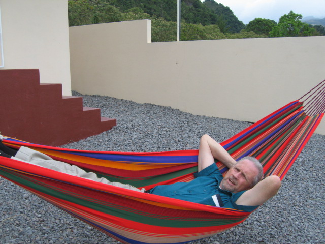 a man sits inside a colorful hammock