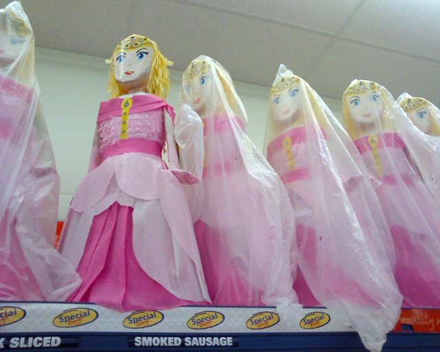 a line of doll toys dressed in pink and yellow