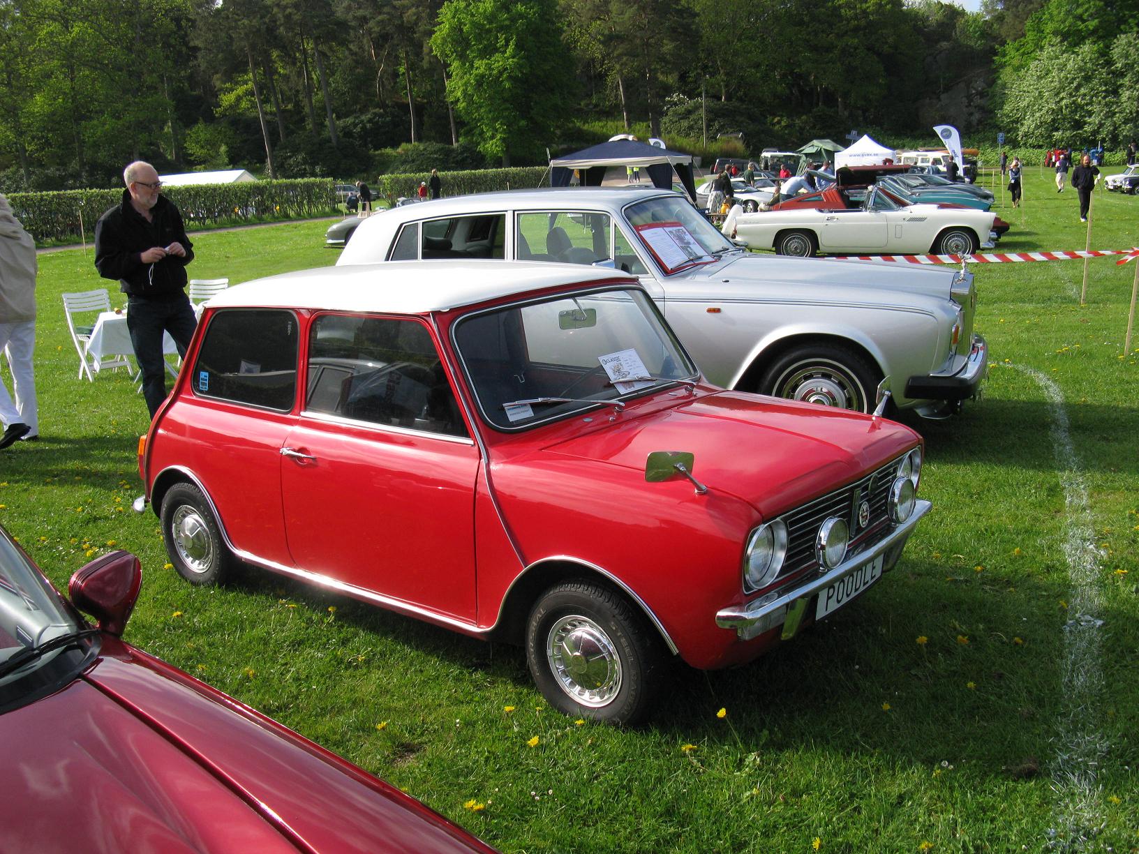 several old cars are parked in a field