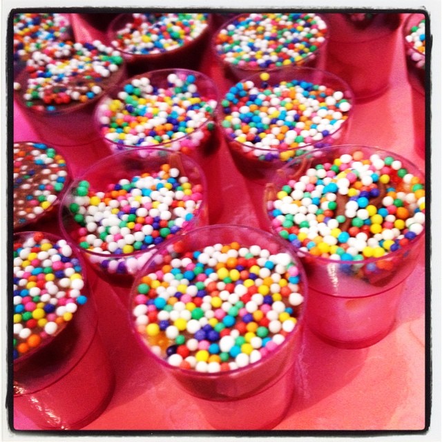 a close up of many small cupcakes in plastic cups
