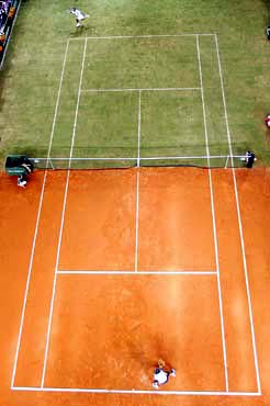 people playing tennis in a large open court