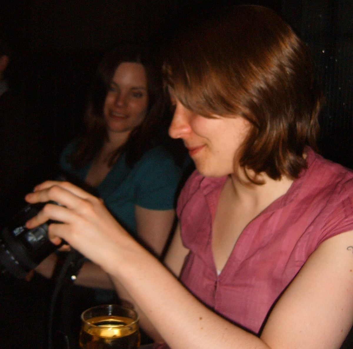 two women laughing and using a digital camera