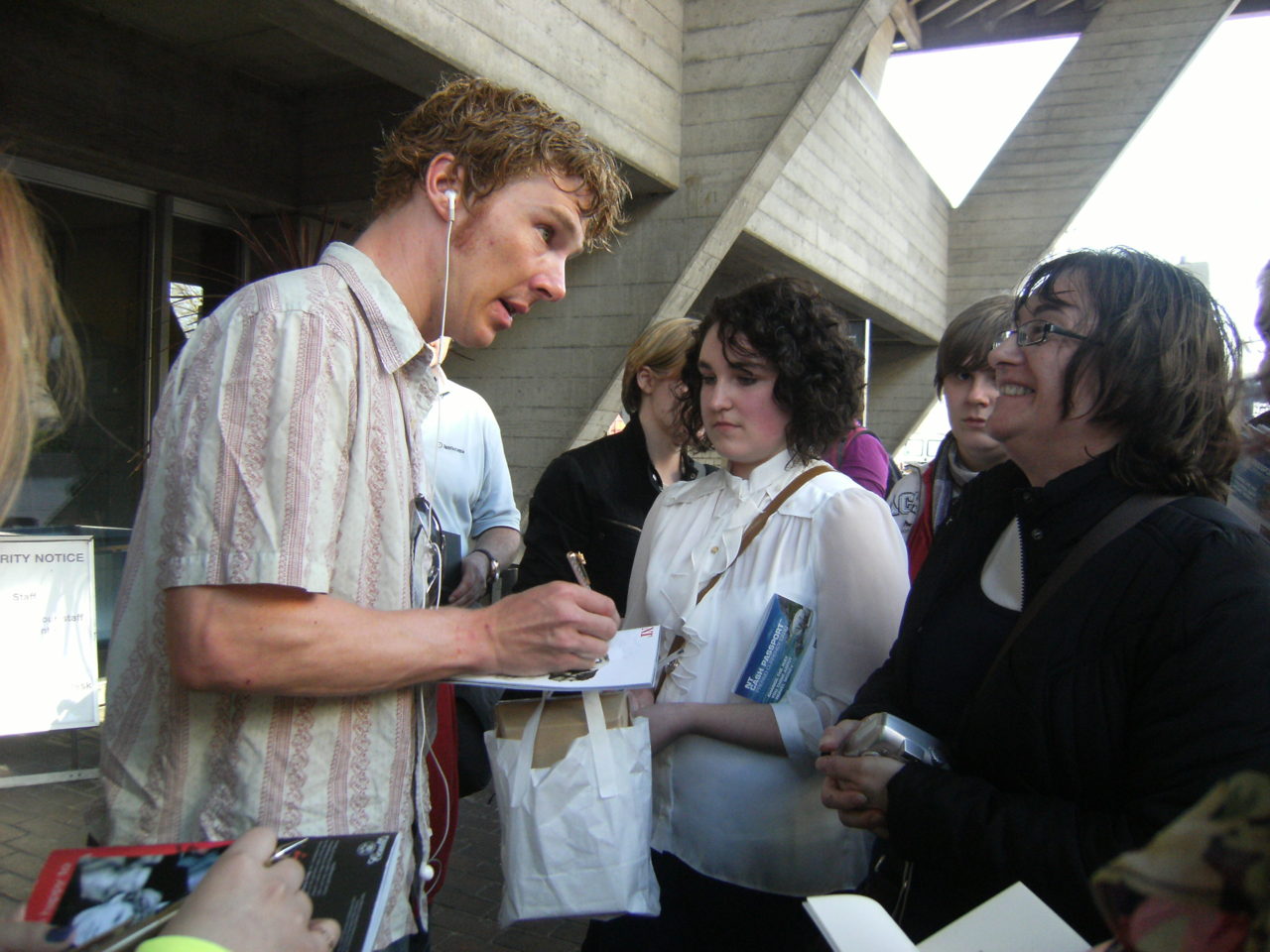 a man is standing by other people in front of some buildings