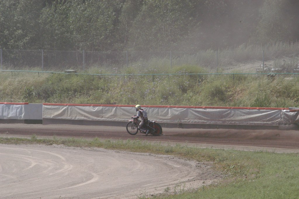 a man on a motor bike passing a race track