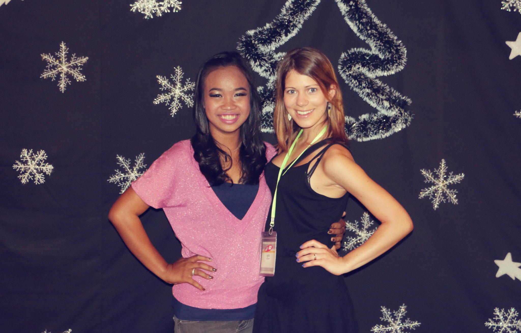 two young women standing next to each other near snow flakes