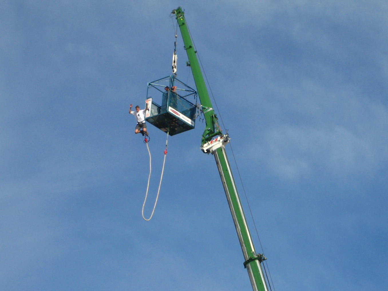 a green lift is being used to lift two people