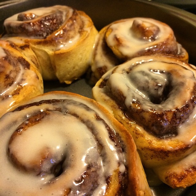 cinnamon buns with frosting in an oven