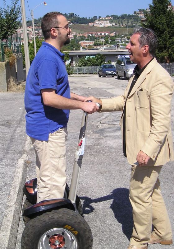 two men shaking hands while hing a hand - powered device