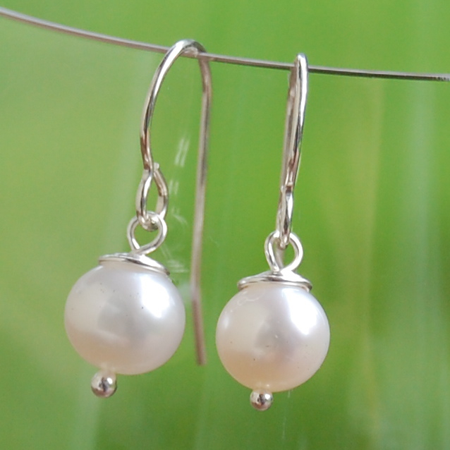 this pair of pearls sits on an open wire