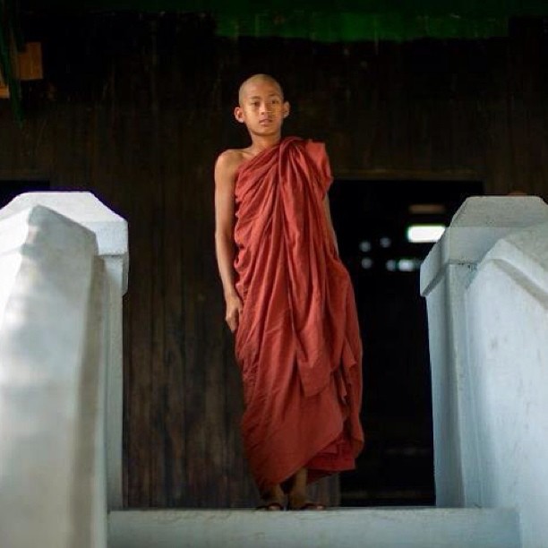 a young monk standing on steps in a building