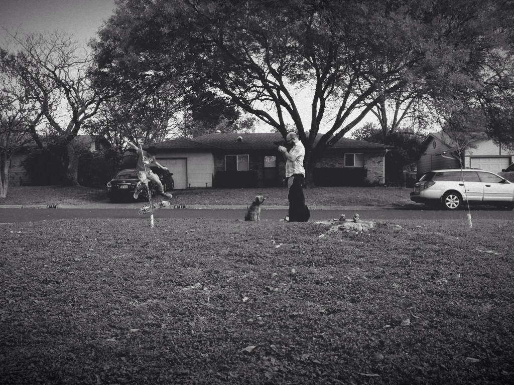 three people are playing catch in the grass