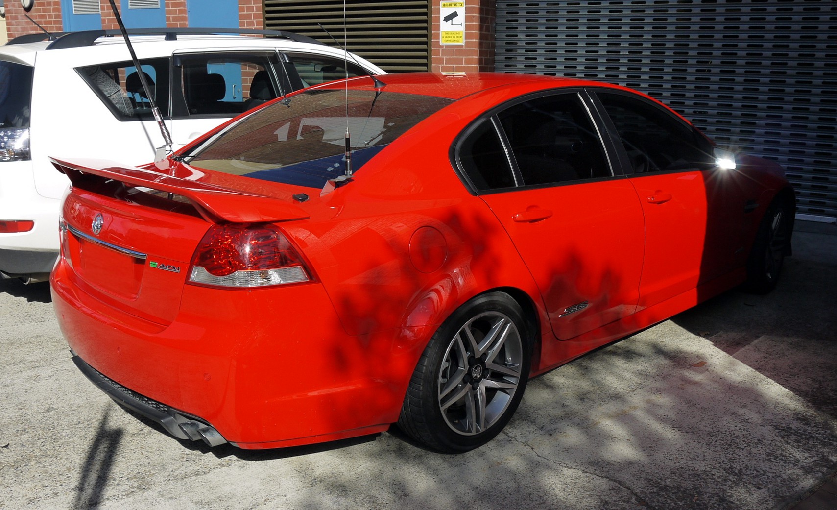 a red car parked in front of a white car