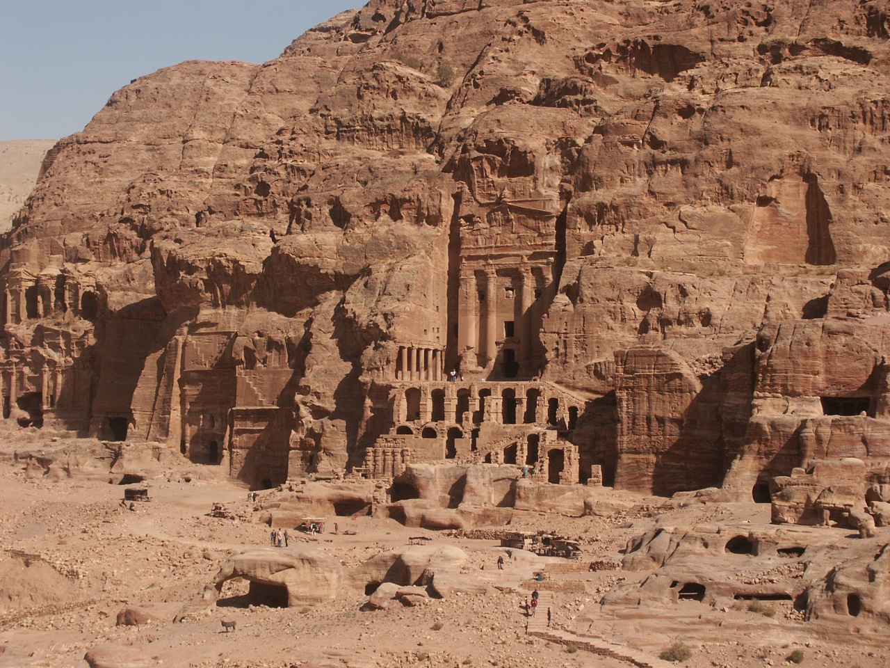 tourists in a canyon near some ruins, near the shore