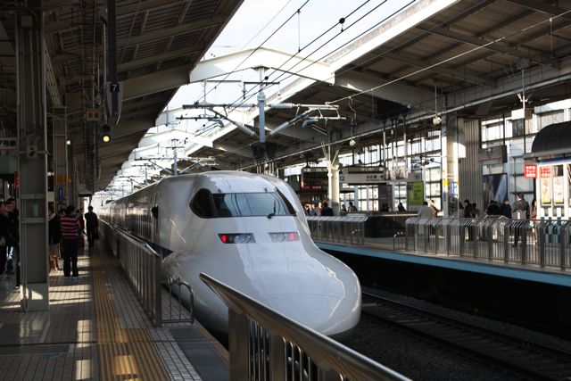 a white bullet train pulling into a station