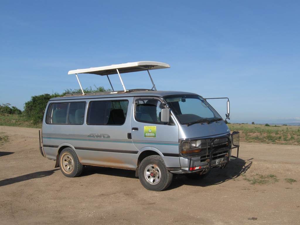 an old gray van with a white top and a sky background