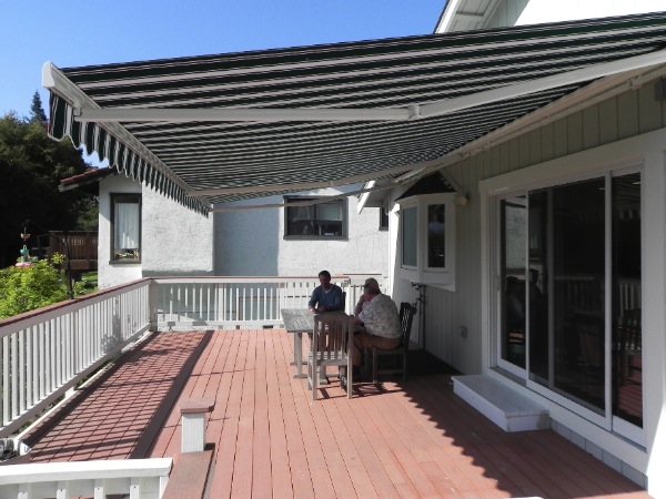 two men sitting on top of a wooden deck